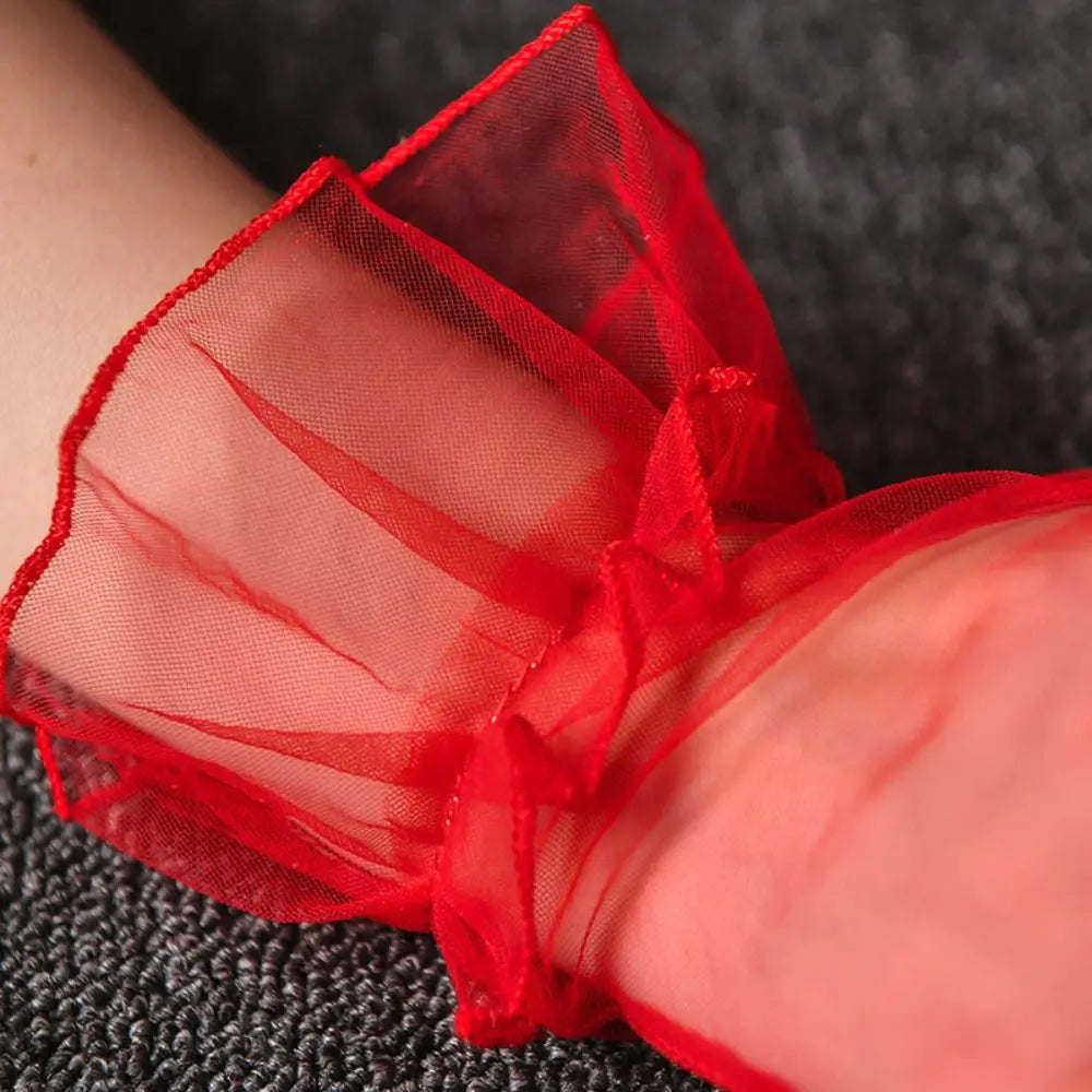 Grande plano do folho largo de tule vermelho no pulso