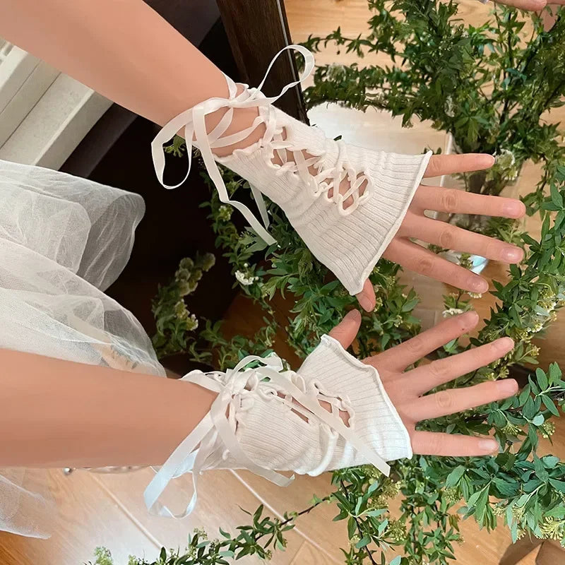 Twee handen met korte witte vingerloze handschoenen en linten voor bladeren