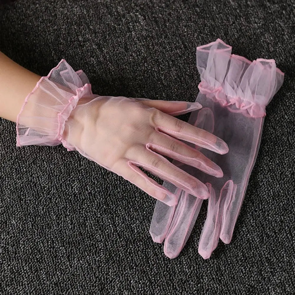 Par de luvas rosa-pálido transparentes com folhos, uma delas usada
