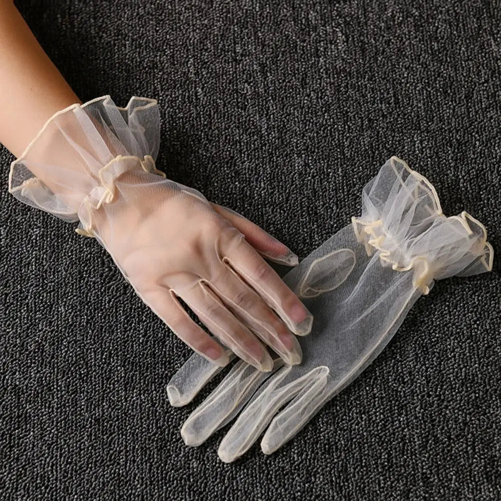 Par de luvas transparentes cor de marfim com folhos, uma delas usada