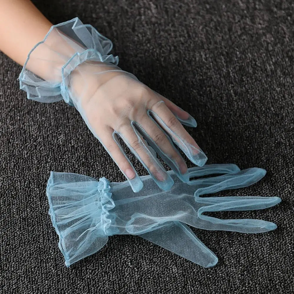 Par de luvas azul-claras transparentes com folhos, uma delas usada