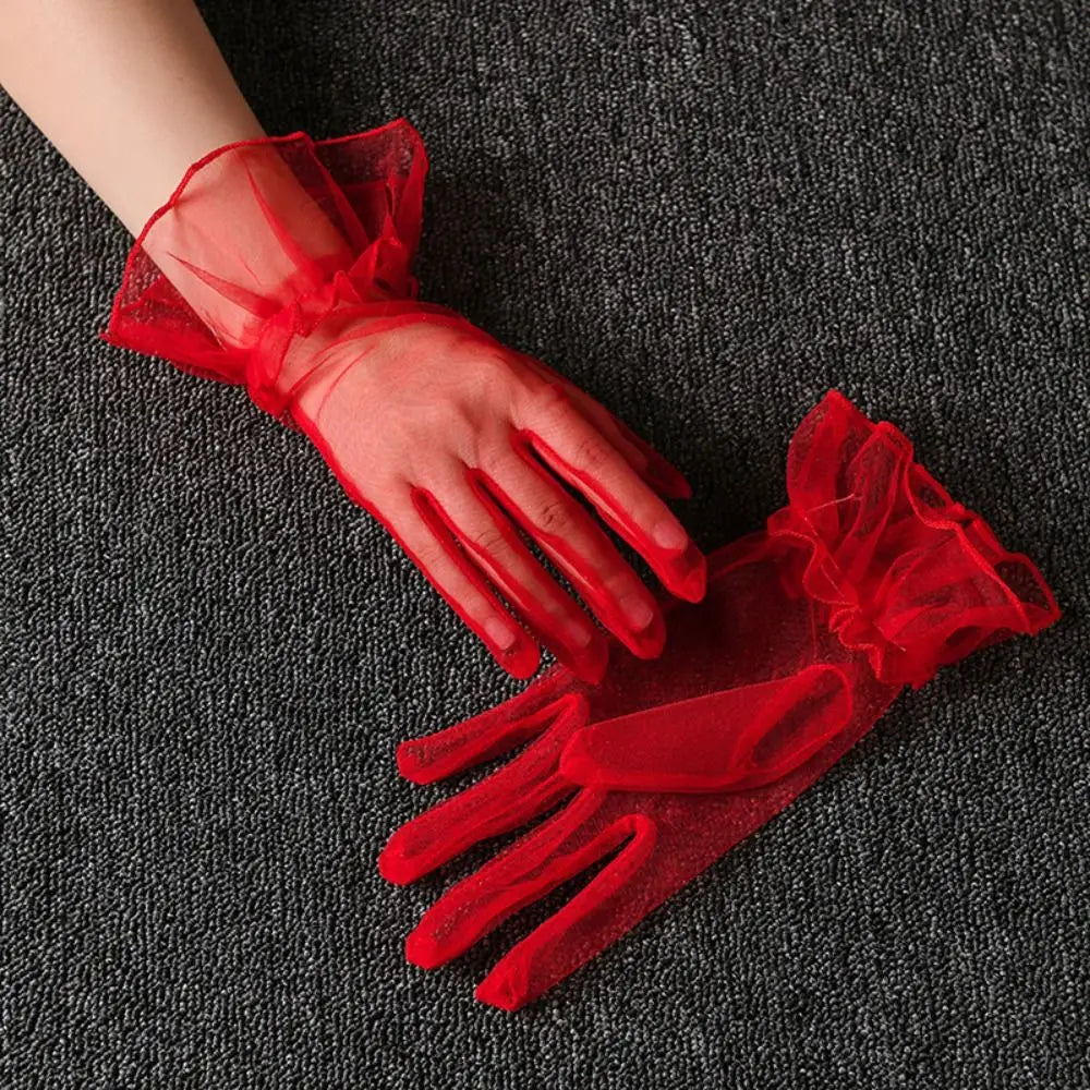 Par de luvas vermelhas vivas transparentes com folhos, uma delas usada