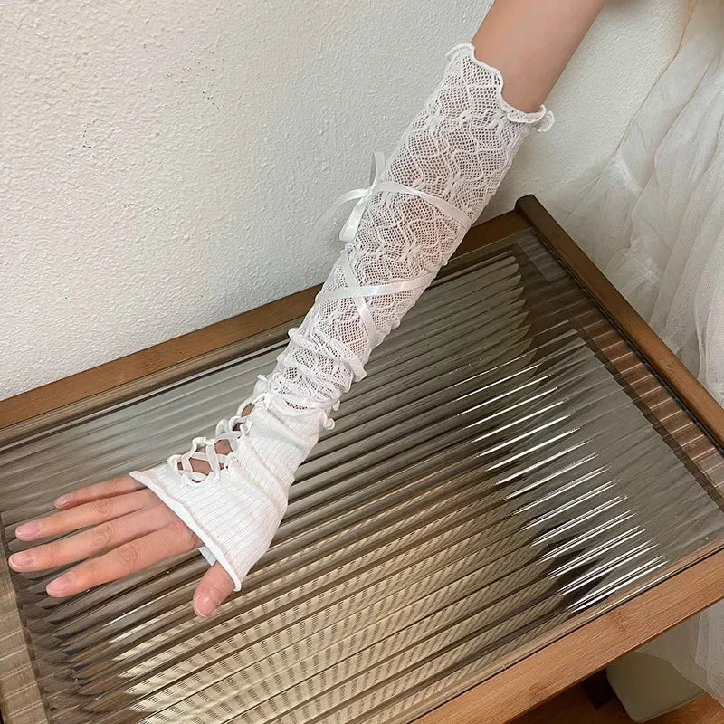 Lange witte kanten vingerloze handschoen met linten op een geribbelde glazen tafel