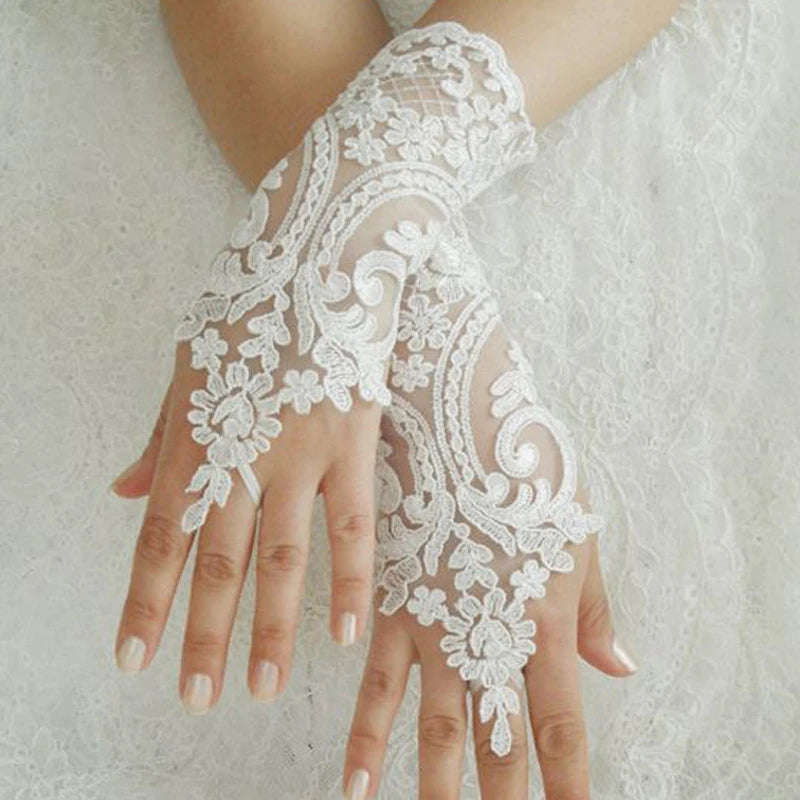 Duas mãos cruzadas com luvas brancas sem dedos em renda sobre um vestido branco
